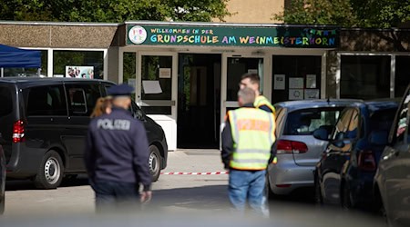 Polizisten stehen vor einer Schule im Berliner Bezirk Spandau, an der es am Vormittag einen möglichen Messerangriff auf einen Schüler gab. / Foto: Jörg Carstensen/dpa