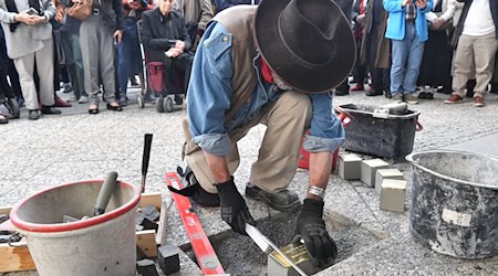 Der Künstler Gunter Demnig verlegt vier Stolpersteine zu Ehren ehemaliger jüdischer Mitglieder der Berliner Philharmoniker. / Foto: Paul Zinken/dpa