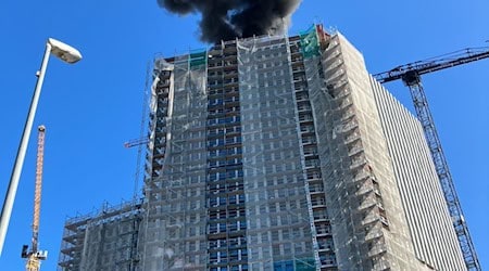 Die Ursache für das Feuer auf dem Dach eines Hochhauses ist noch unklar.  / Foto: Dirk Wittenberg/dpa