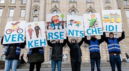 Mitglieder der Initiative «Berlin autofrei» halten vor dem Gerichtsgebäude Schilder hoch für das Wort «Verkehrsentscheid!». (Archivbild)  / Foto: Carsten Koall/dpa