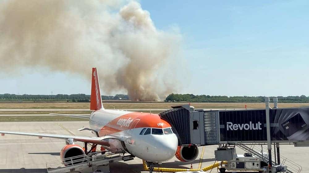 Ein Brand auf einem Getreidefeld ganz in der Nähe des Flughafens BER erzeugt auch bei Fluggästen Aufmerksamkeit.  / Foto: Tobias Schmidt/dpa