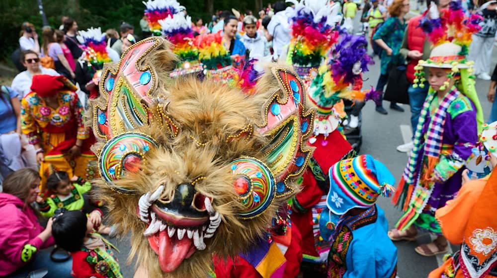 Kinder in traditionellen Kostümen tanzen am Mariannenplatz zur Musik. / Foto: Annette Riedl/dpa