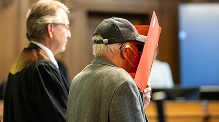 Der Angeklagte (r) steht vor Beginn des Prozesses mit seinem Anwalt Thomas Scheferling in einem Gerichtssaal. / Foto: Hannes P. Albert/dpa