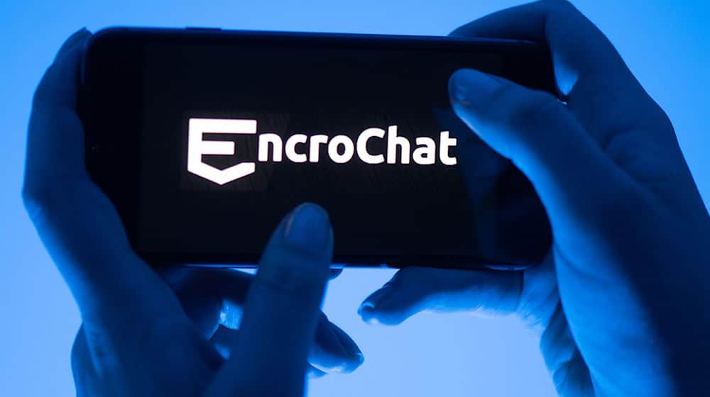 Eine Frau hält ein Smartphone mit dem Logo des Krypto-Messengerdienstes Encrochat. (Symbolbild)  / Foto: Sebastian Kahnert/dpa