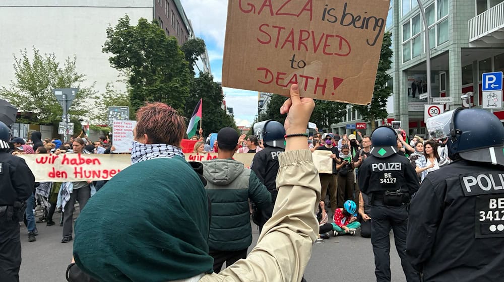 «Gaza wird ausgehungert» - das kritisieren Demonstranten am Checkpoint Charlie in Berlin-Mitte. / Foto: Caroline Bock/dpa