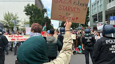«Gaza wird ausgehungert» - das kritisieren Demonstranten am Checkpoint Charlie in Berlin-Mitte. / Foto: Caroline Bock/dpa