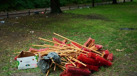 Besen liegen bereit für das große Aufräumen nach dem Rave.  / Foto: Annette Riedl/dpa