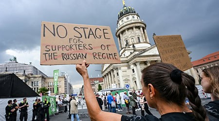 Demonstranten am Gendarmenmarkt protestierten gegen den Auftritt der Starsopranistin Anna Netrebko beim Musikfestival «Classic Open Air».  / Foto: Jens Kalaene/dpa