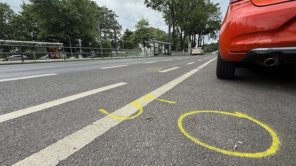 Kreide, aufgezeichnet von der Polizei, zeigen auf der Straße an der Wuhlheide Fundorte von Spuren nach einem tödlichen Verkehrsunfall. (Archivbild)  / Foto: Paul Zinken/dpa