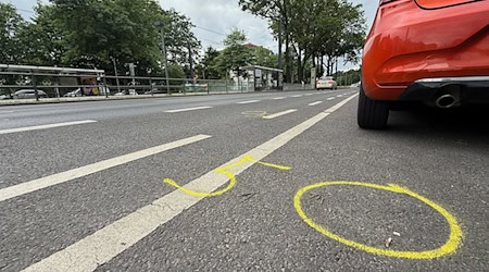 Kreide, aufgezeichnet von der Polizei, zeigen auf der Straße an der Wuhlheide Fundorte von Spuren nach einem tödlichen Verkehrsunfall. (Archivbild)  / Foto: Paul Zinken/dpa