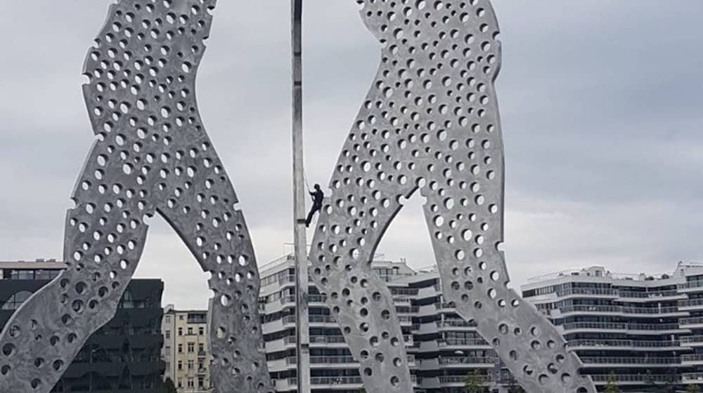 Polizisten kletterten auf die Skulptur «Molecule Man», nachdem dort Aktivisten ein Banner angebracht hatten. / Foto: Polizei Berlin/dpa