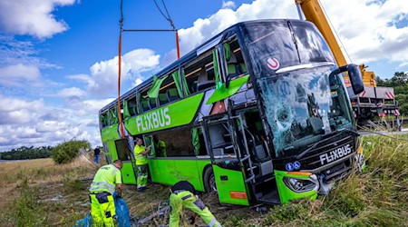 Per Kran sollte der verunfallte Bus geborgen werden. / Foto: Jens Büttner/dpa