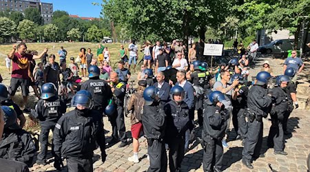 Demonstrierende und Polizisten stehen im Görlitzer Park.  / Foto: Andreas Heimann/dpa
