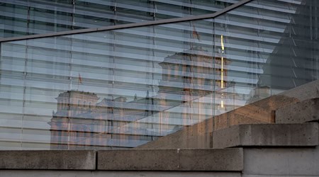 Das Reichstagsgebäude spiegelt sich in einer Scheibe des Marie-Elisabeth-Lüders-Haus, wo traditionell das ARD-Sommerinterview erfolgt. (Archivbild)  / Foto: Hannes P. Albert/dpa