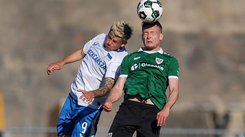 Kopfballduell zwischen dem Münsteraner Paul Jaeckel (rechts) und Herthas Dawid Kownacki. / Foto: Friso Gentsch/dpa