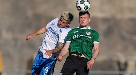 Kopfballduell zwischen dem Münsteraner Paul Jaeckel (rechts) und Herthas Dawid Kownacki. / Foto: Friso Gentsch/dpa