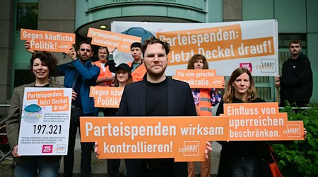 Mitglieder von Lobbycontrol demonstrieren vor einer Verhandlung über eine Klage gegen die Bundestagsverwaltung wegen Großspenden für die Berliner CDU. (Archivbild)  / Foto: Sebastian Christoph Gollnow/dpa