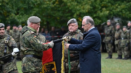 Sachsen-Anhalts Ministerpräsident Reiner Haseloff befestigte an der Fahne das Band mit dem Namen des Regiments. / Foto: Klaus-Dietmar Gabbert/dpa