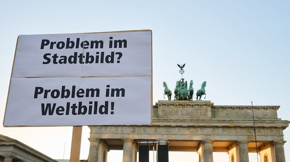 Demonstranten vor dem Brandenburger Tor kritisierten die «Stadtbild»-Äußerungen von Bundeskanzler Friedrich Merz (CDU). / Foto: Annette Riedl/dpa