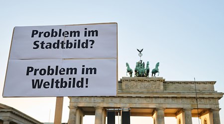 Demonstranten vor dem Brandenburger Tor kritisierten die «Stadtbild»-Äußerungen von Bundeskanzler Friedrich Merz (CDU). / Foto: Annette Riedl/dpa