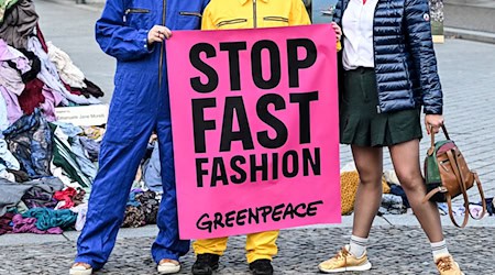 Die Umweltschützer wollen mit der Kunst-Aktion ein Zeichen gegen Müllberge aus Klamotten setzen, für die sie die Modeindustrie mitverantwortlich machen. / Foto: Jens Kalaene/dpa