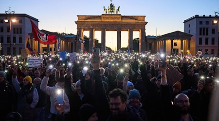 Hunderte von Demonstranten bilden mit Smartphones und Feuerzeugen ein Lichtermeer.  / Foto: Annette Riedl/dpa