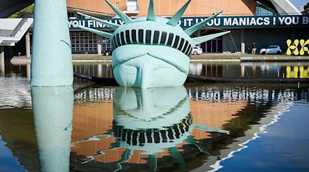 Böhmermann-Ausstellung: Der halbe Kopf einer aufblasbaren Freiheitsstatue, das Kunstwerk «Status of Liberty» liegt in dem Gewässer vor dem Haus der Kulturen der Welt. / Foto: Annette Riedl/dpa