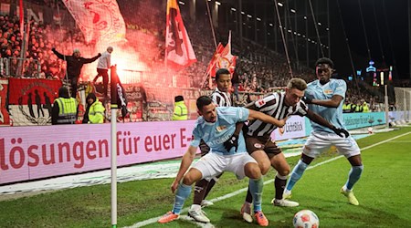 Viel Einsatz: Rani Khedira (l) und Derrick Köhn (r) von Union Berlin im Kampf um den Ball mit Hauke Wahl und Joel Chima Fujita vom FC St. Pauli. / Foto: Christian Charisius/dpa
