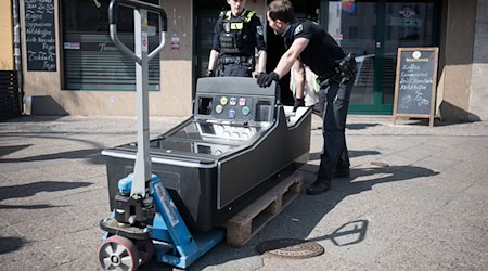Beamte transportieren einen Spielautomaten aus einem Lokal. (Archivbild)  / Foto: Sebastian Gollnow/dpa