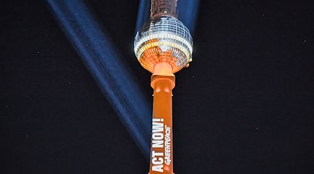 Die Umweltschutz-Organisation Greenpeace projiziert einen Appell auf den Berliner Fernsehturm.  / Foto: Paul Zinken/dpa