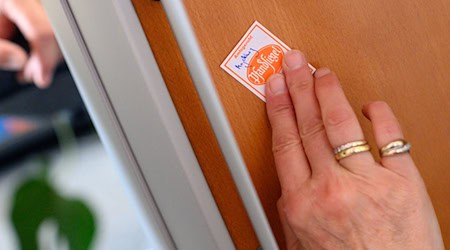 Eine Gerichtsvollzieherin klebt ein Pfandsiegel auf ein technisches Gerät. (Symbolbild)  / Foto: Klaus-Dietmar Gabbert/dpa