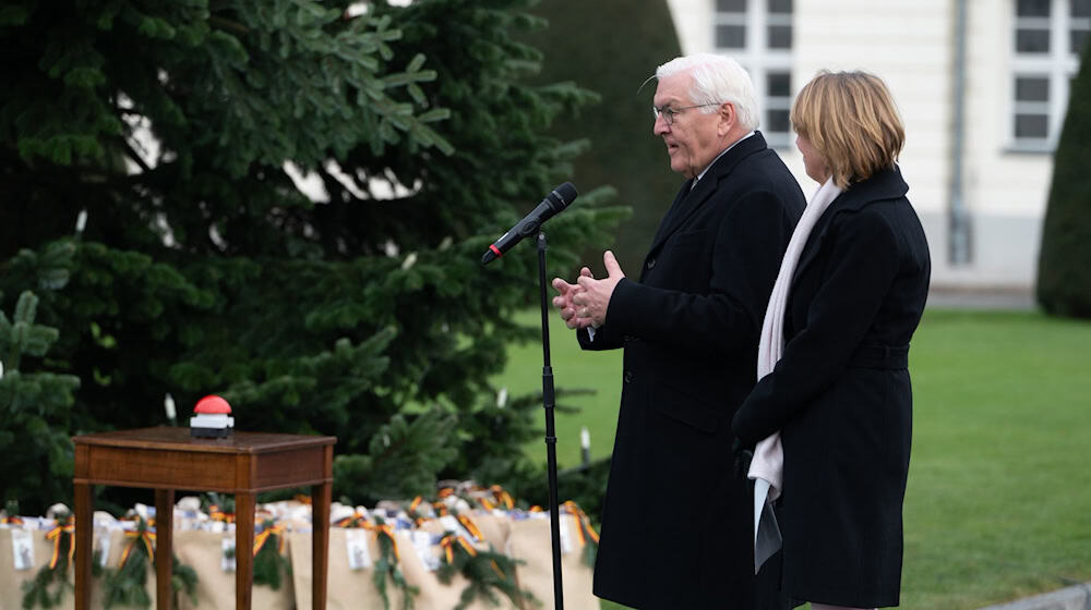 Bundespräsident Frank-Walter Steinmeier (l) und seine Frau Elke Büdenbender schalten die Beleuchtung des Weihnachtsbaums vor dem Schloss Bellevue ein.  / Foto: Markus Lenhardt/dpa