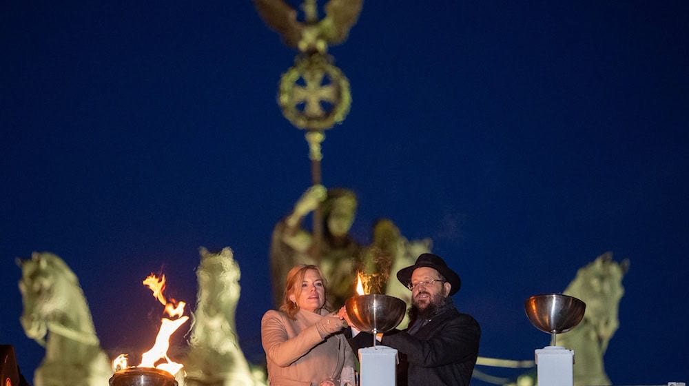 Bundestagspräsidentin Julia Klöckner und Rabbiner Yehudi Teichtal entzünden ein Licht. / Foto: Soeren Stache/dpa