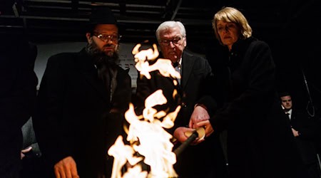 Stunden nach dem brutalen Anschlag in Sydney zündeten Rabbiner Yehuda Teichtal (l), Bundespräsident Frank-Walter Steinmeier und seine Frau Elke Büdenbender gemeinsam eine Fackel für die erste Kerze des Chanukka-Leuchters vor dem Brandenburg Tor an.  / Foto: Carsten Koall/dpa