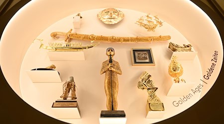 Eine Vitrine der Ausstellung enthält Goldgeschenke. / Foto: Elisa Schu/dpa