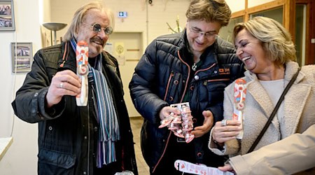 Musiker Frank Zander und sein Sohn Marcus sowie Petra Biernoth bei der Übergabe von gestifteten Zahnbürsten in der Notübernachtung der Berliner Kältehilfe der Caritas. / Foto: Britta Pedersen/dpa