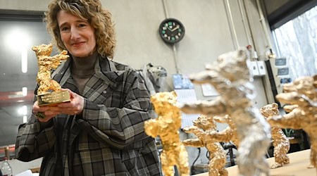 Festivalchefin Tricia Tuttle zeigt einen der Bären. / Foto: Britta Pedersen/dpa