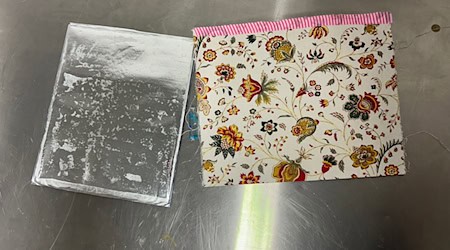 Eine Postkarte aus Spanien enthielt unter einer Folie versteckt Kokain.  / Foto: Christiane Ullrich/Hauptzollamt Potsdam/dpa