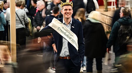 In den Hallen der Grünen Woche ragt er mit seiner Größe von 2,04 Meter heraus: Brandenburgs Erntekönig Christian Braune.  / Foto: Britta Pedersen/dpa