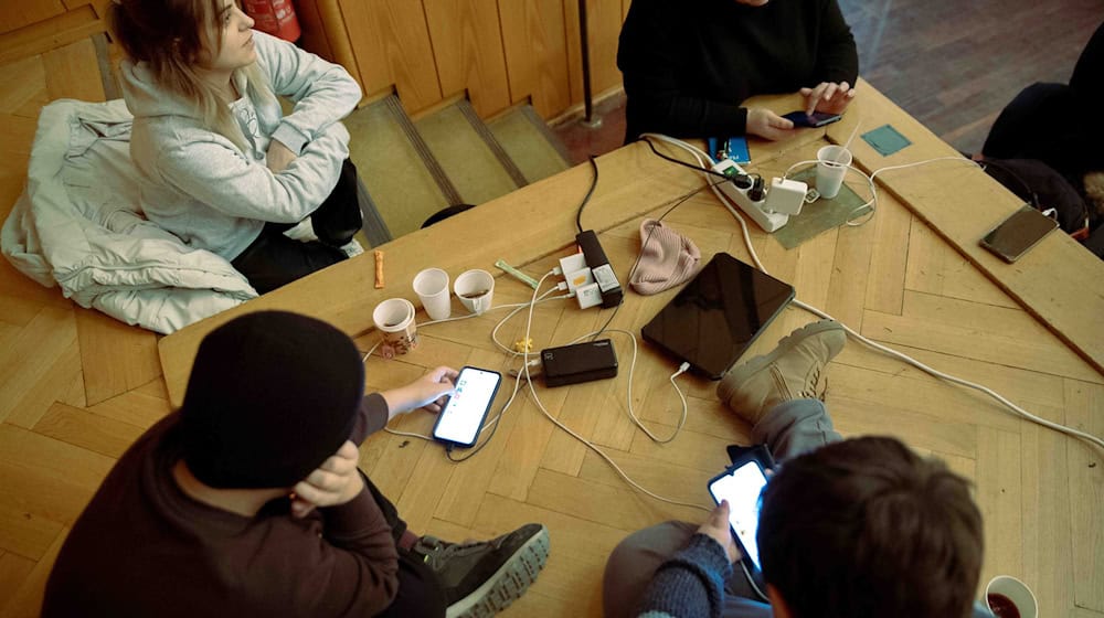 Um ihre Mobiltelefone aufzuladen, kommen Einwohner der vom Stromausfall betroffenen Gebiete im Südwesten Berlin ins Rathaus Zehlendorf. / Foto: Carsten Koall/dpa