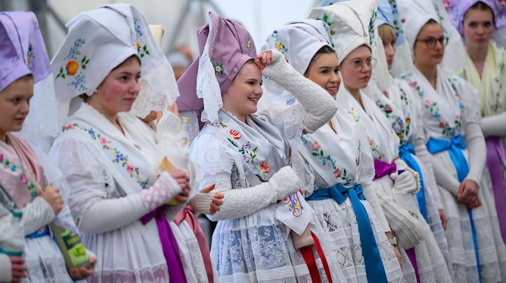 Junge Frauen in traditioneller wendischer Festtagstracht feiern bei einem Fastnachtsumzug. / Foto: Patrick Pleul/dpa