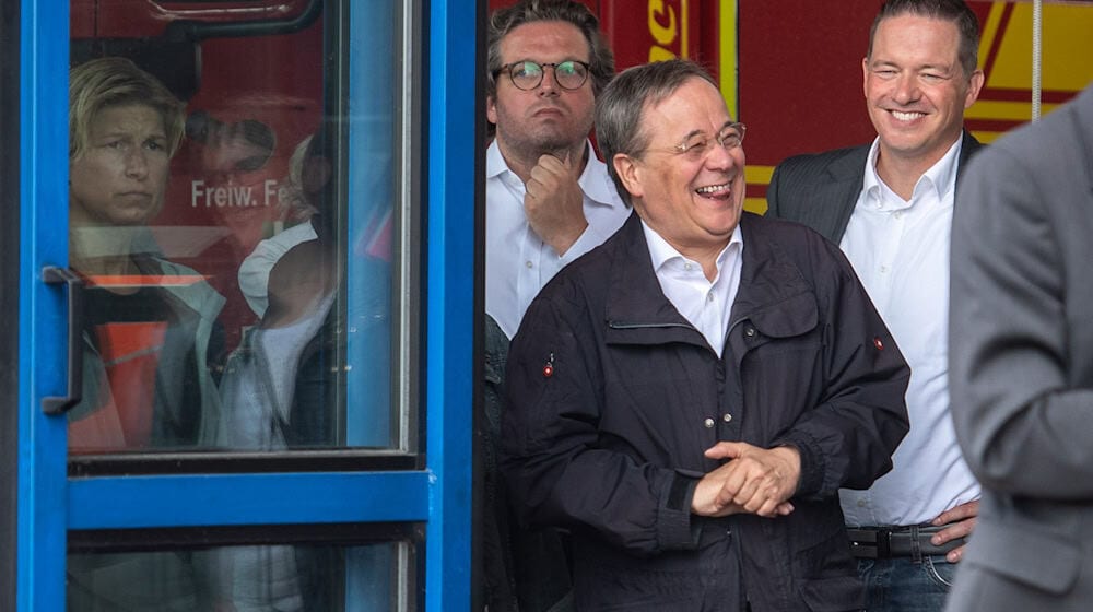 Der Laschet-Moment. Der damalige Unionskanzlerkandidat Armin Laschet (CDU) lachte nach der Ahrtal-Katastrophe bei einem Besuch der Region im Juli 2021, während Bundespräsident Frank-Walter Steinmeier sich zu dem Unglück äußerte. (Archivbild) / Foto: Marius Becker/dpa