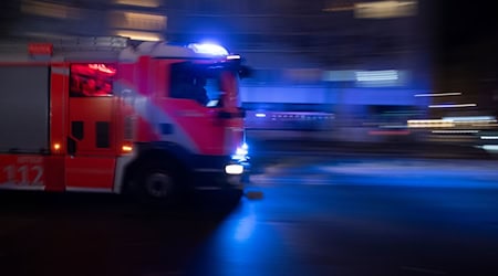 Die Feuerwehr löscht brennende Weihnachtsbäume auf einer Kreuzung in Friedrichshain.  / Foto: Paul Zinken/dpa