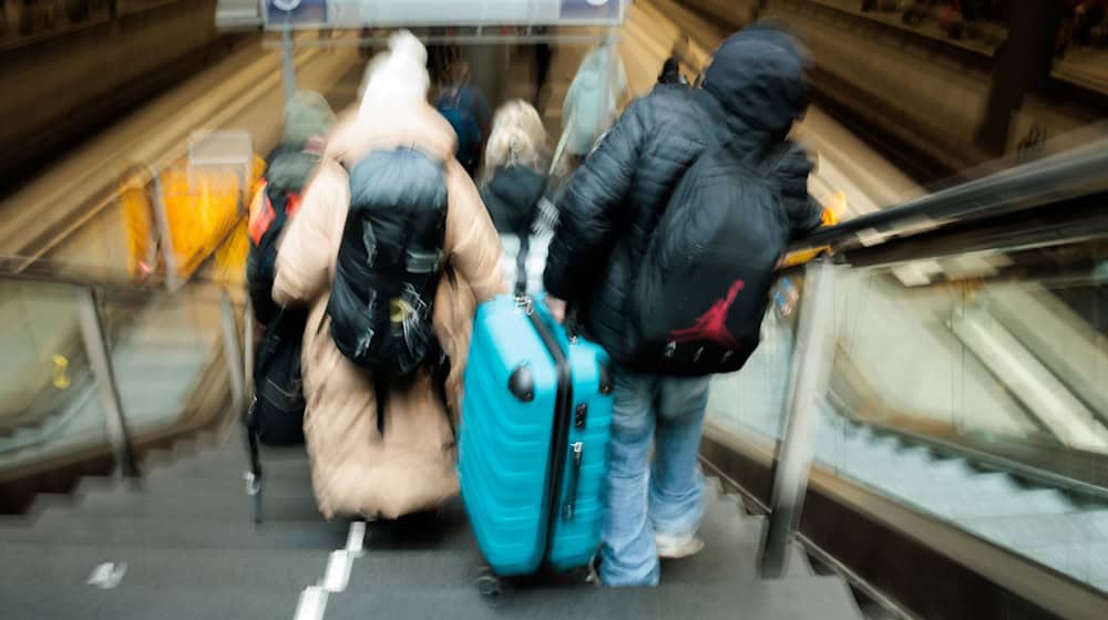 Reisende tragen auf dem Berliner Hauptbahnhof neben den gesperrten Rolltreppen große Koffer die Treppen hinab zum Bahnsteig.  / Foto: Carsten Koall/dpa