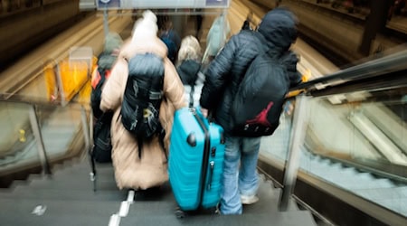Reisende tragen auf dem Berliner Hauptbahnhof neben den gesperrten Rolltreppen große Koffer die Treppen hinab zum Bahnsteig.  / Foto: Carsten Koall/dpa