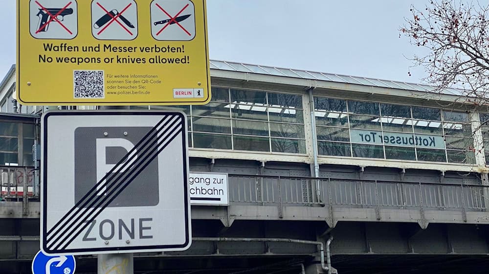 Gelbe Schilder weisen auf die Waffen- und Messerbotszone am Kottbusser Tor in Berlin-Kreuzberg hin. / Foto: Torsten Holz/dpa