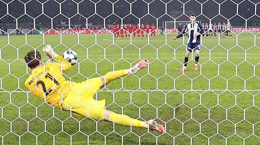 Freiburgs Keeper Florian Müller pariert im Elfmeterschießen gegen Hertha BSC zwei Schüsse.  / Foto: Andreas Gora/dpa
