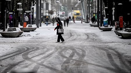 Passanten gehen durch Schneematsch am Potsdamer Platz. / Foto: Britta Pedersen/dpa