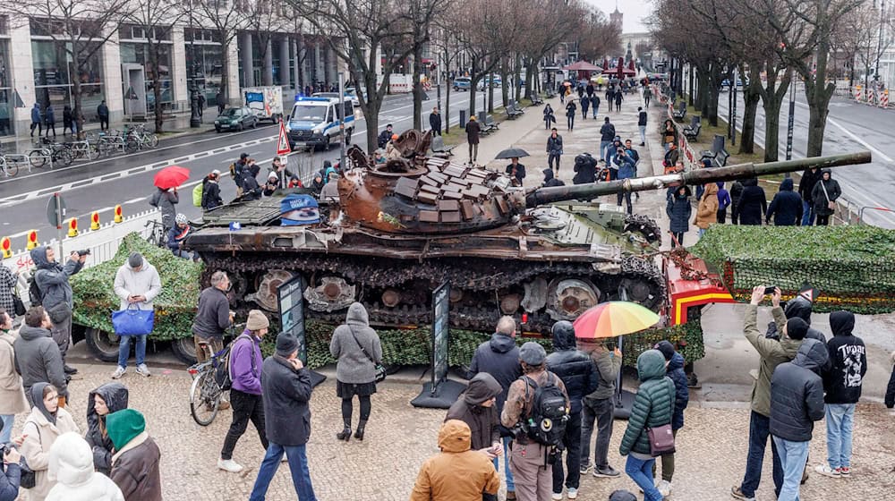 Passanten stehen 2023 vor einem in der Ukraine zerstörten russischen Panzer. (Archivbild)  / Foto: Carsten Koall/dpa