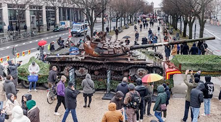 Passanten stehen 2023 vor einem in der Ukraine zerstörten russischen Panzer. (Archivbild)  / Foto: Carsten Koall/dpa